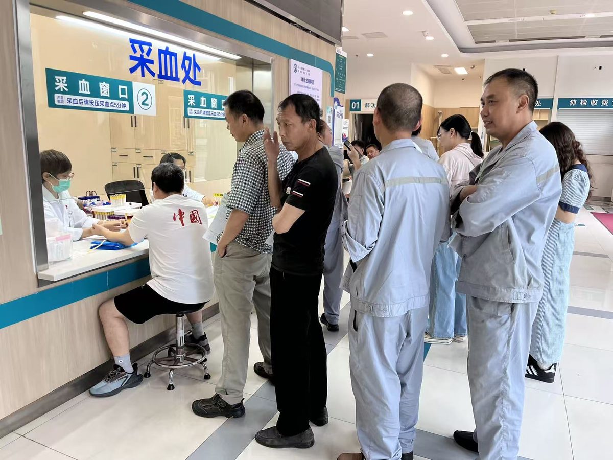 采血处窗口前，员工逐项完成采血化验项目